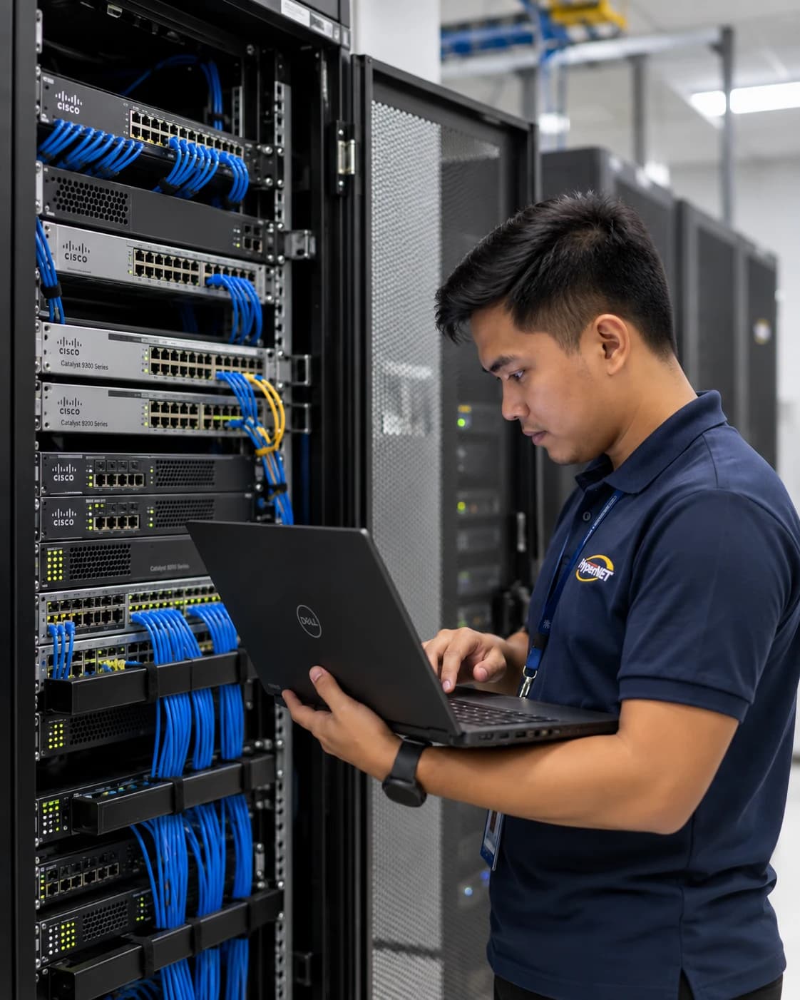 Hypernet technician in profile configuring server rack equipment with a laptop