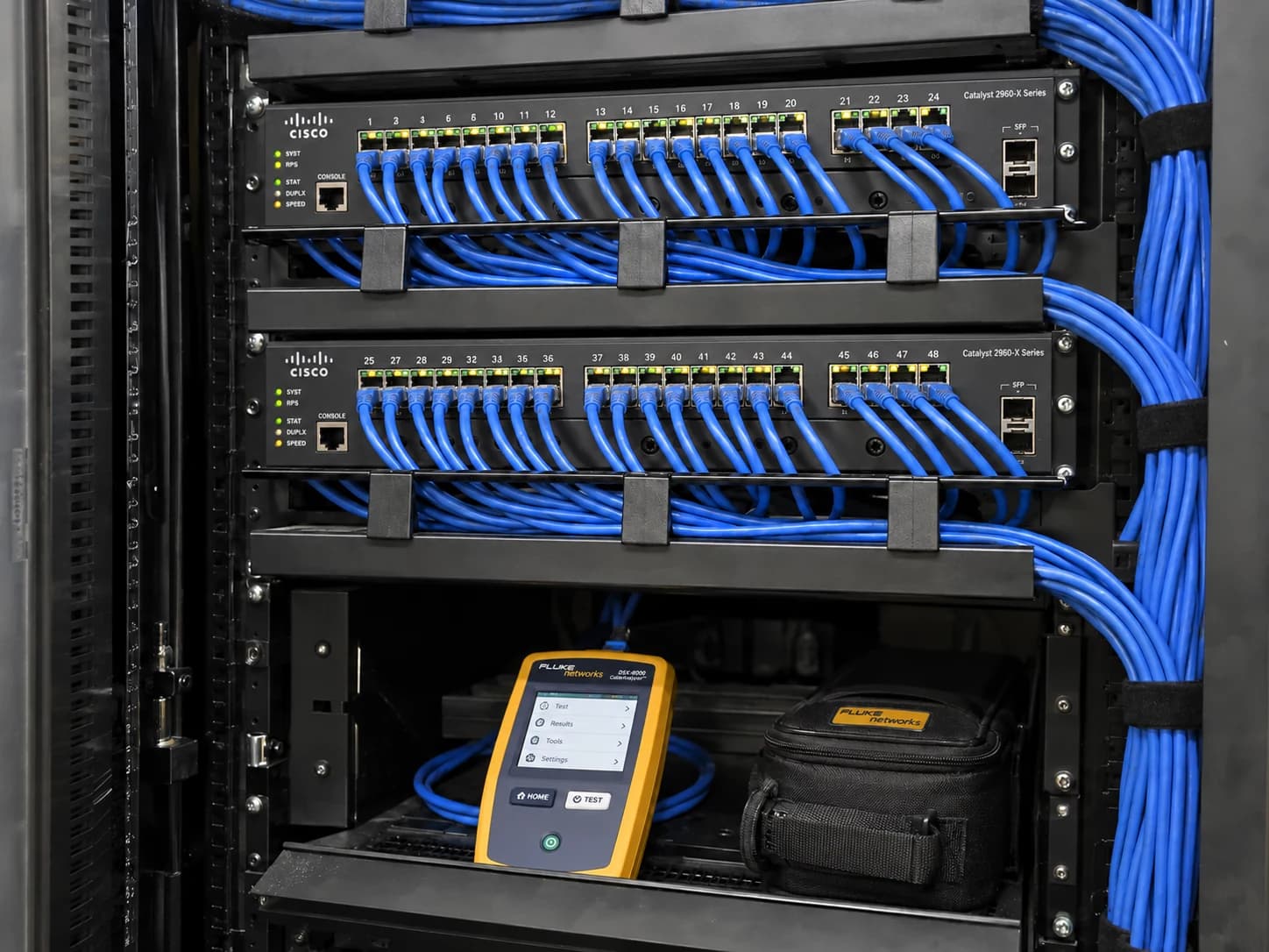 Organized Ethernet patch panels, cable managers and a cable certification tester