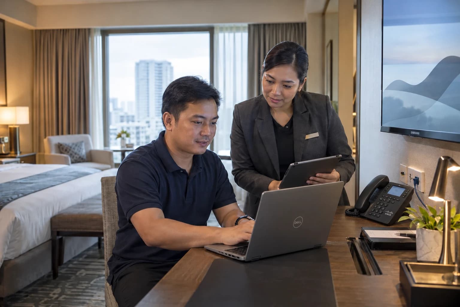 A technician and hotel manager checking guest connectivity and connected room technology