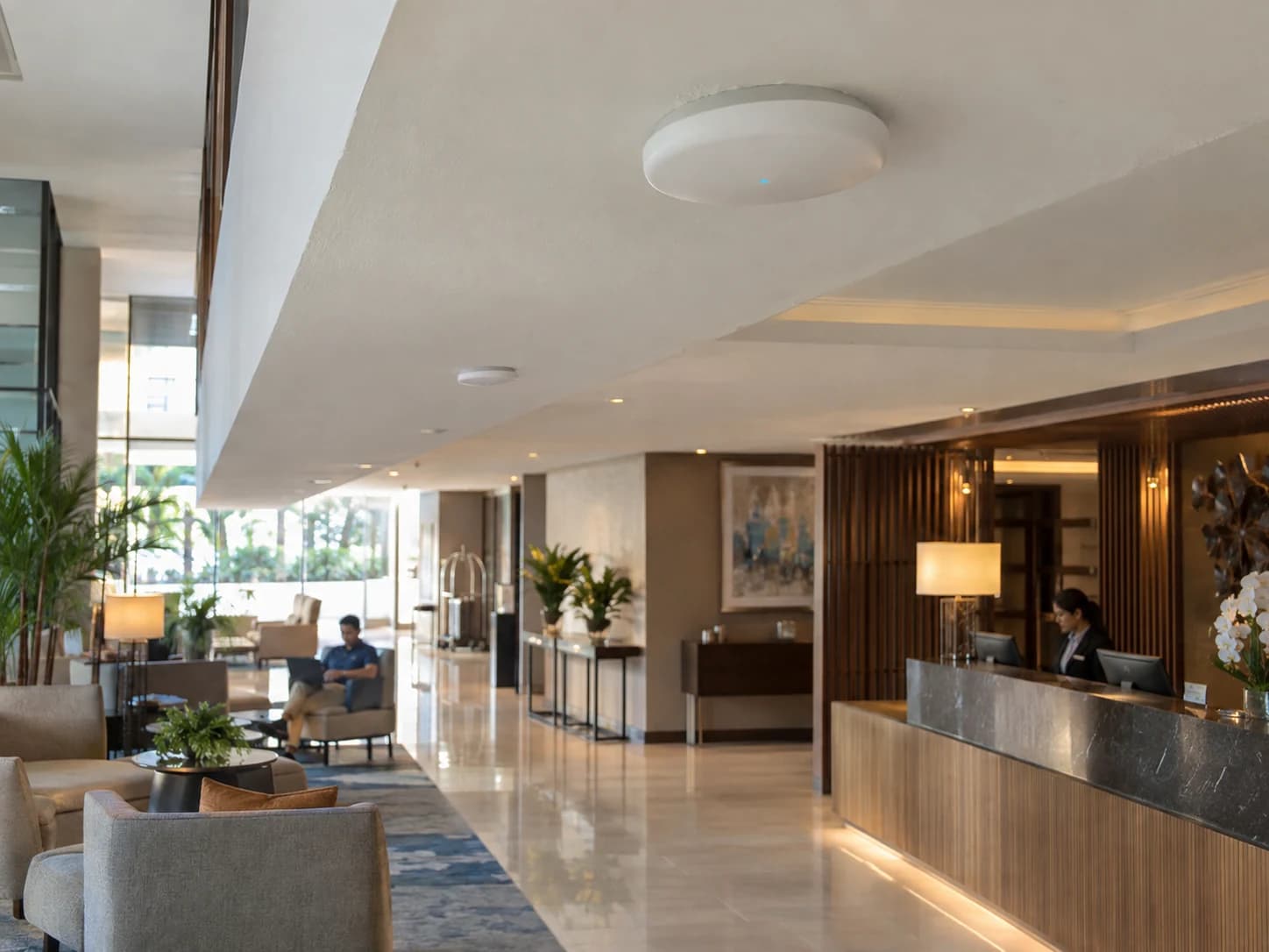 Ceiling-mounted enterprise Wi-Fi access points serving a hotel lobby